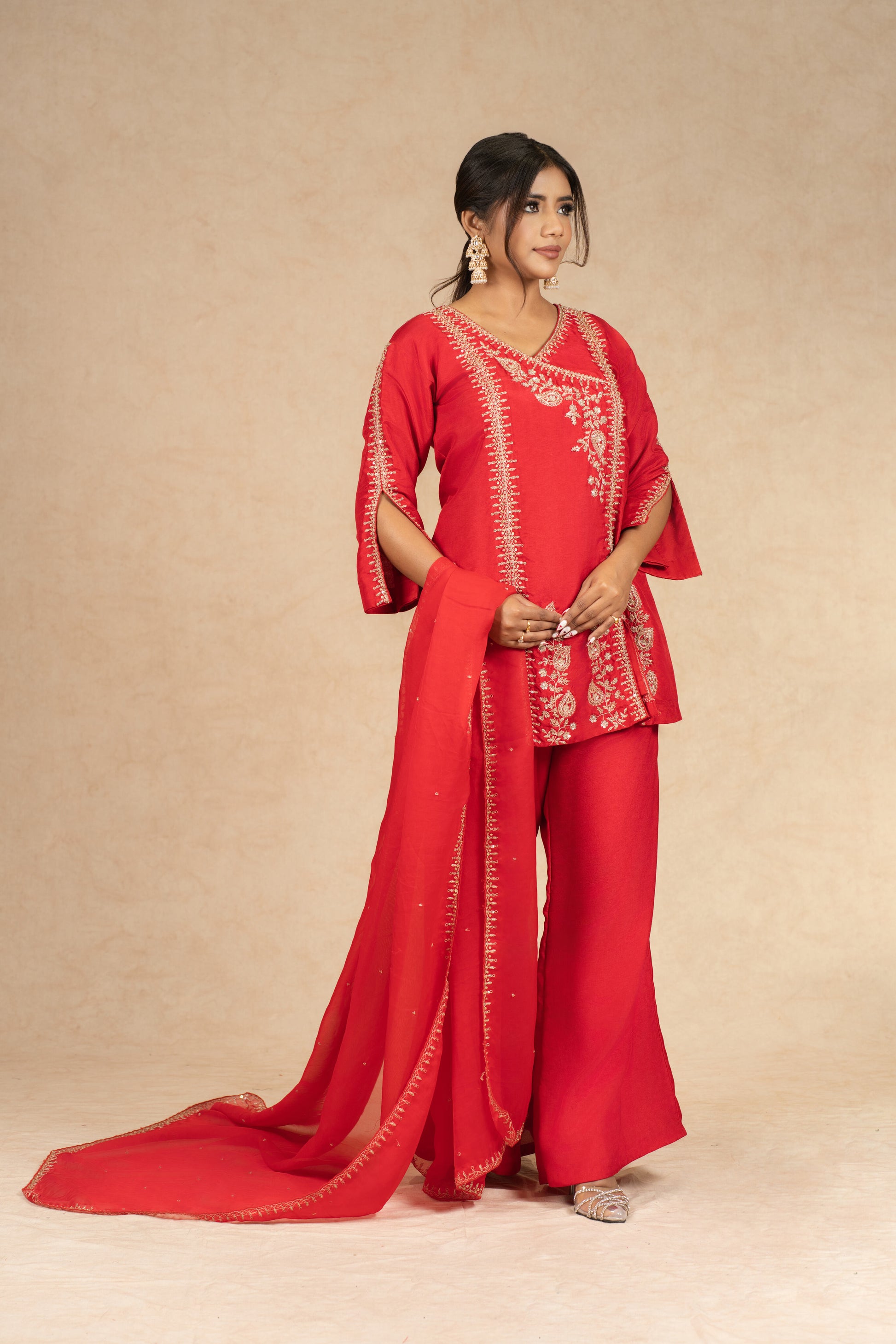 Stylish angle showcasing the flowy silhouette of the Red Silk Suit with beautifully embroidered details.