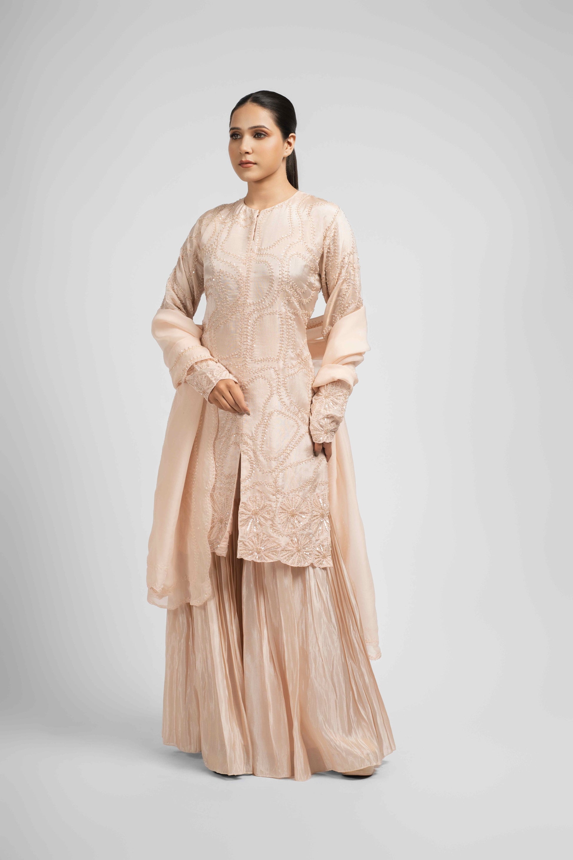 Side profile of a model in a Rose Pink Tissue Sharara Set, showcasing the elegant silhouette and delicate detailing.