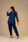 Model elegantly posing in a Royal Blue Co-ord Set with silk pants and a semi-sheer embroidered shirt, exuding sophistication.
