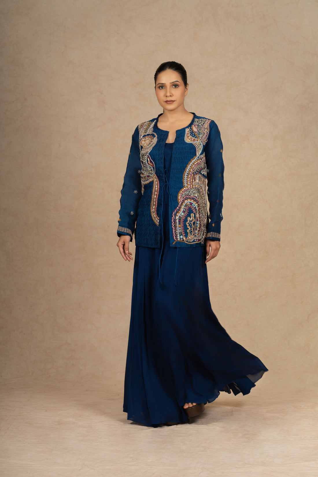 Royal blue Indo Western outfit with intricate embroidery on an organza jacket, paired with a flowy skirt.
