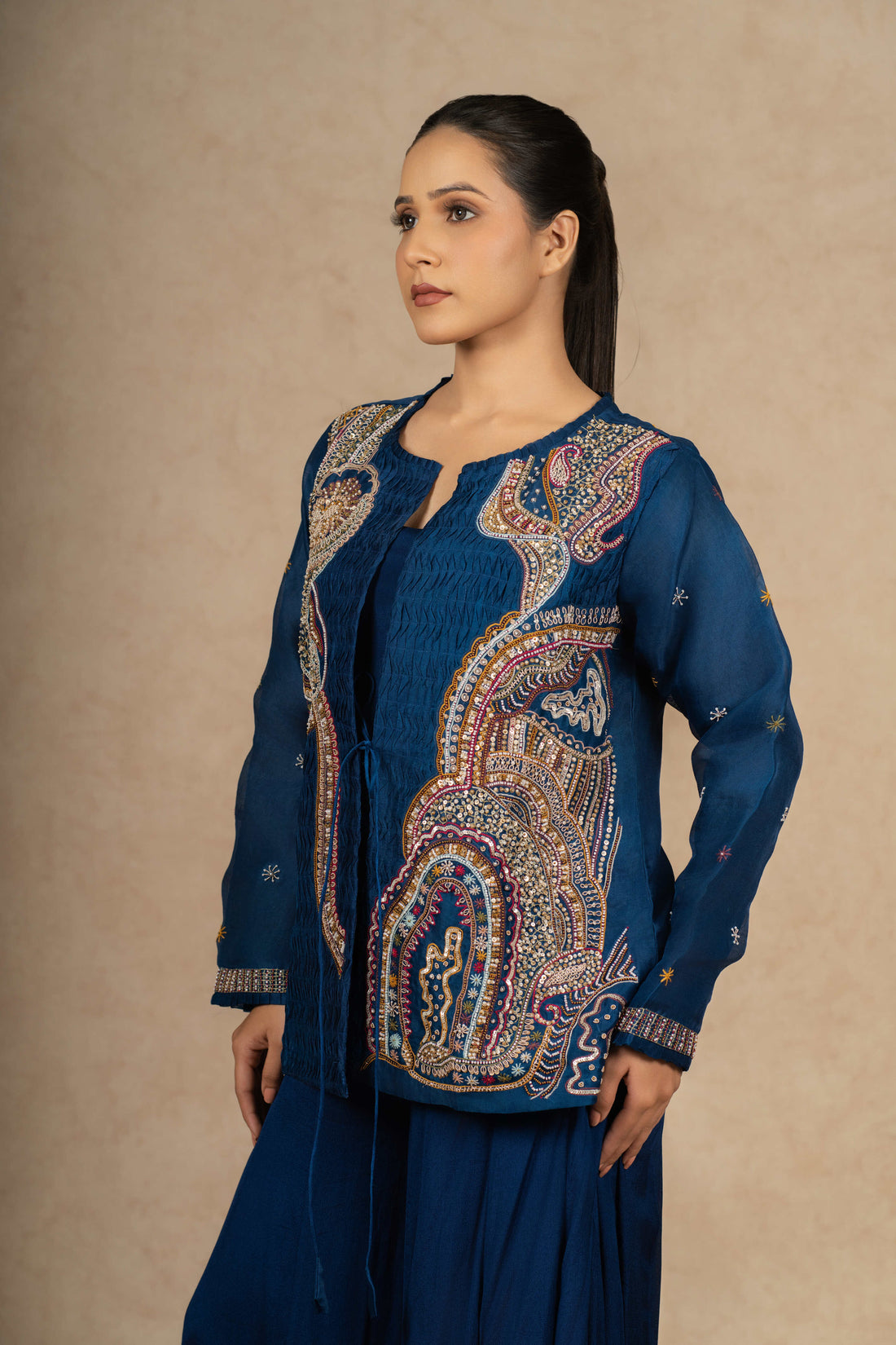 Royal blue Indo Western outfit with intricate embroidery on an organza jacket, paired with a flowy skirt.
