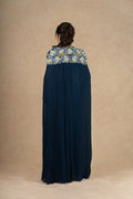 Model showcasing the back design of the Royal Blue Indo-Western dress, featuring a flowing cape with floral embroidered shoulders.