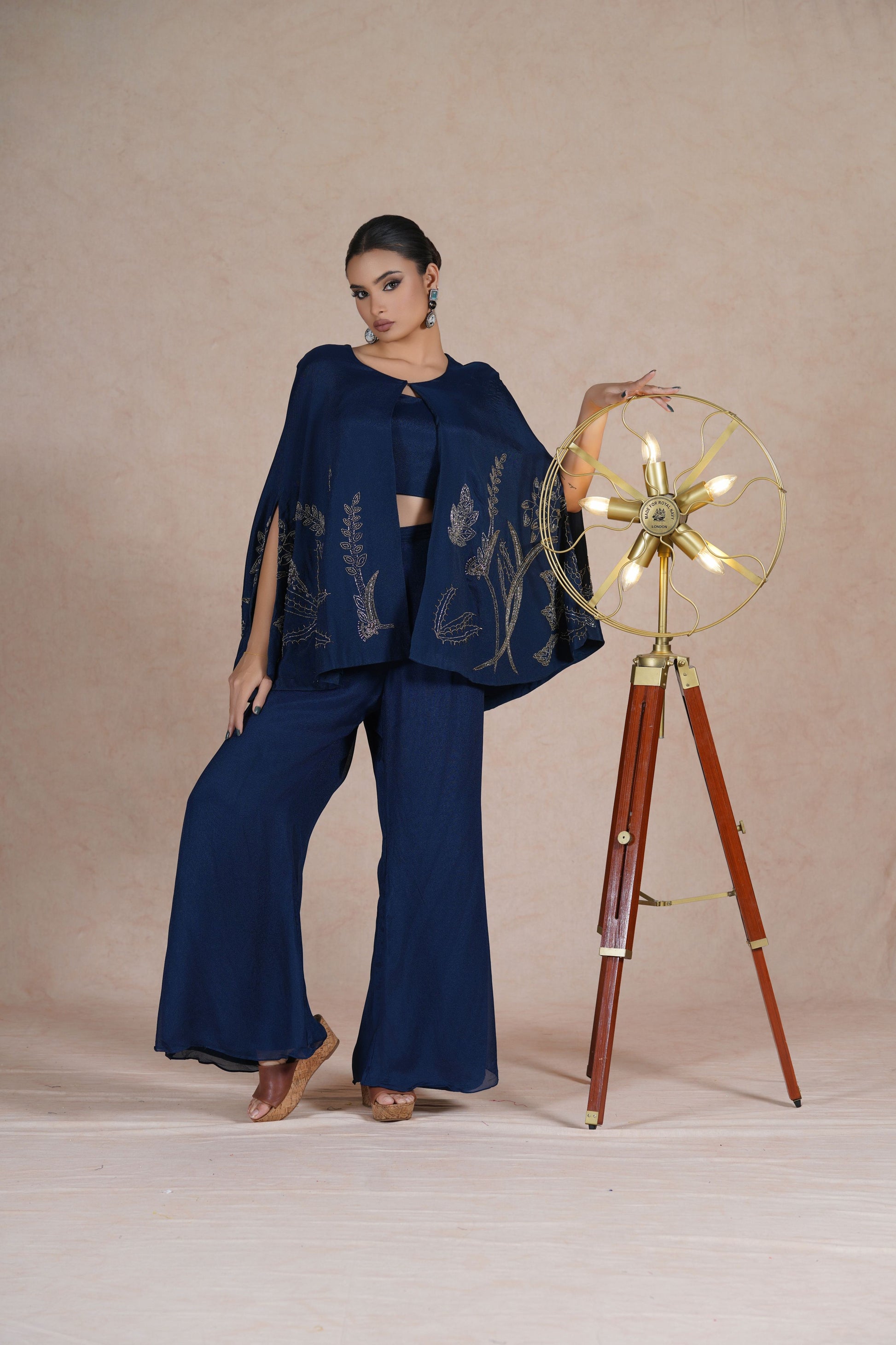 Model posing dynamically in the Royal Blue Indo Western outfit, highlighting the cape’s movement and intricate design.