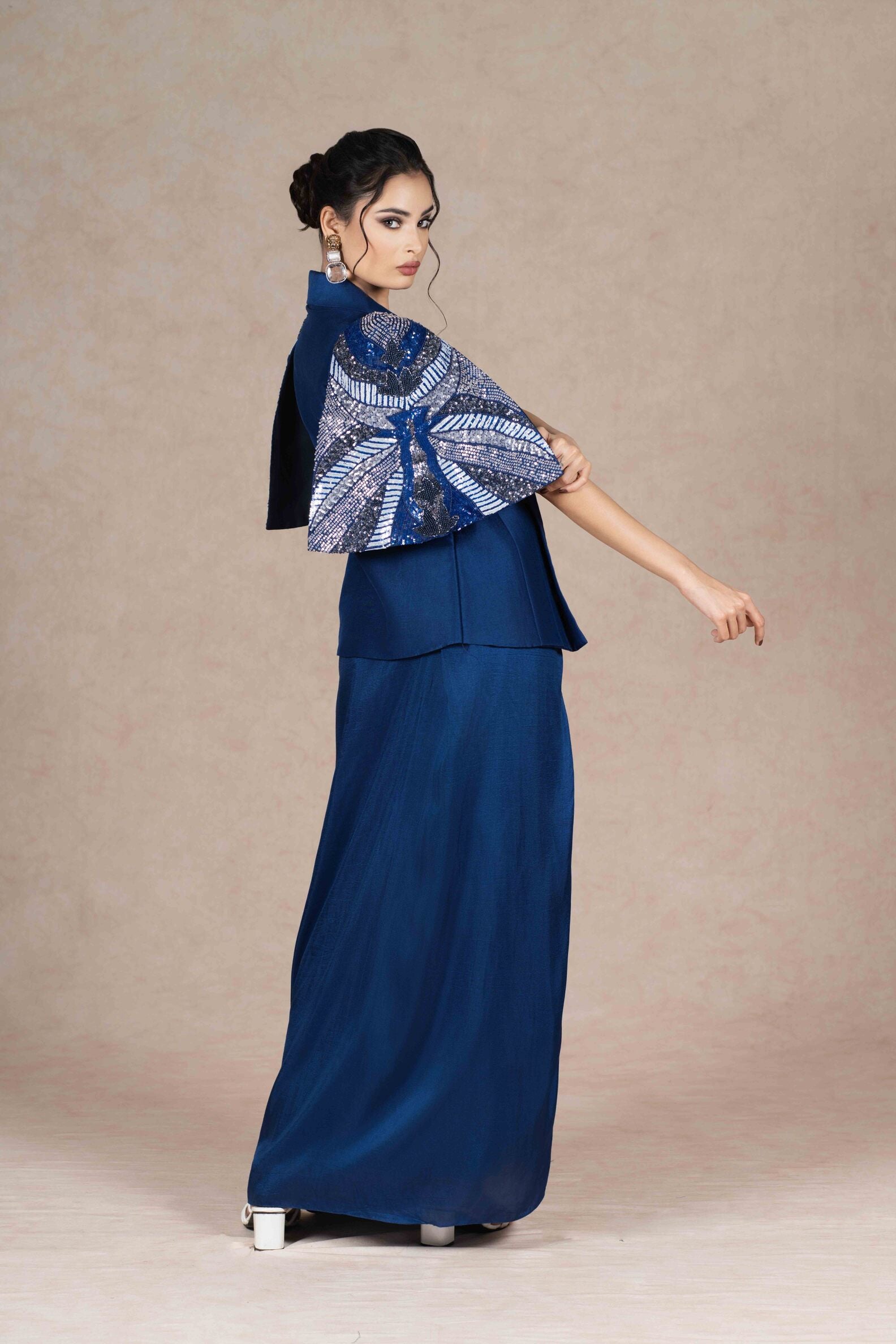 Royal blue embroidered jacket with cape sleeves, sweetheart neckline bustier, and pleated floor-length skirt. Elegant festive or formal ensemble.