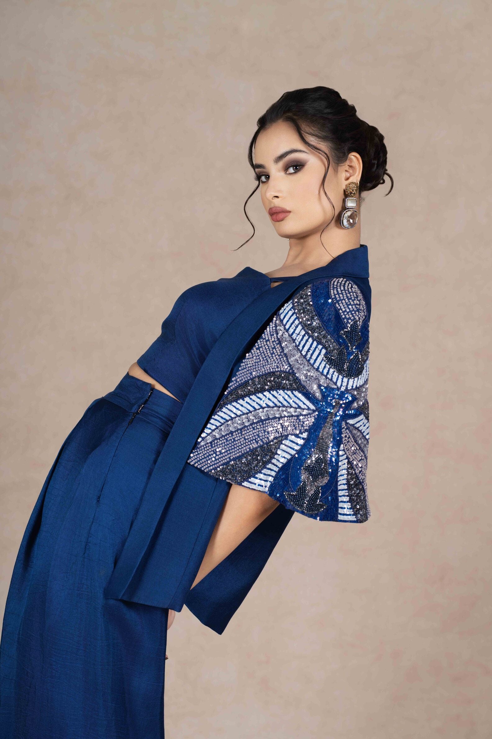 Royal blue embroidered jacket with cape sleeves, sweetheart neckline bustier, and pleated floor-length skirt. Elegant festive or formal ensemble.