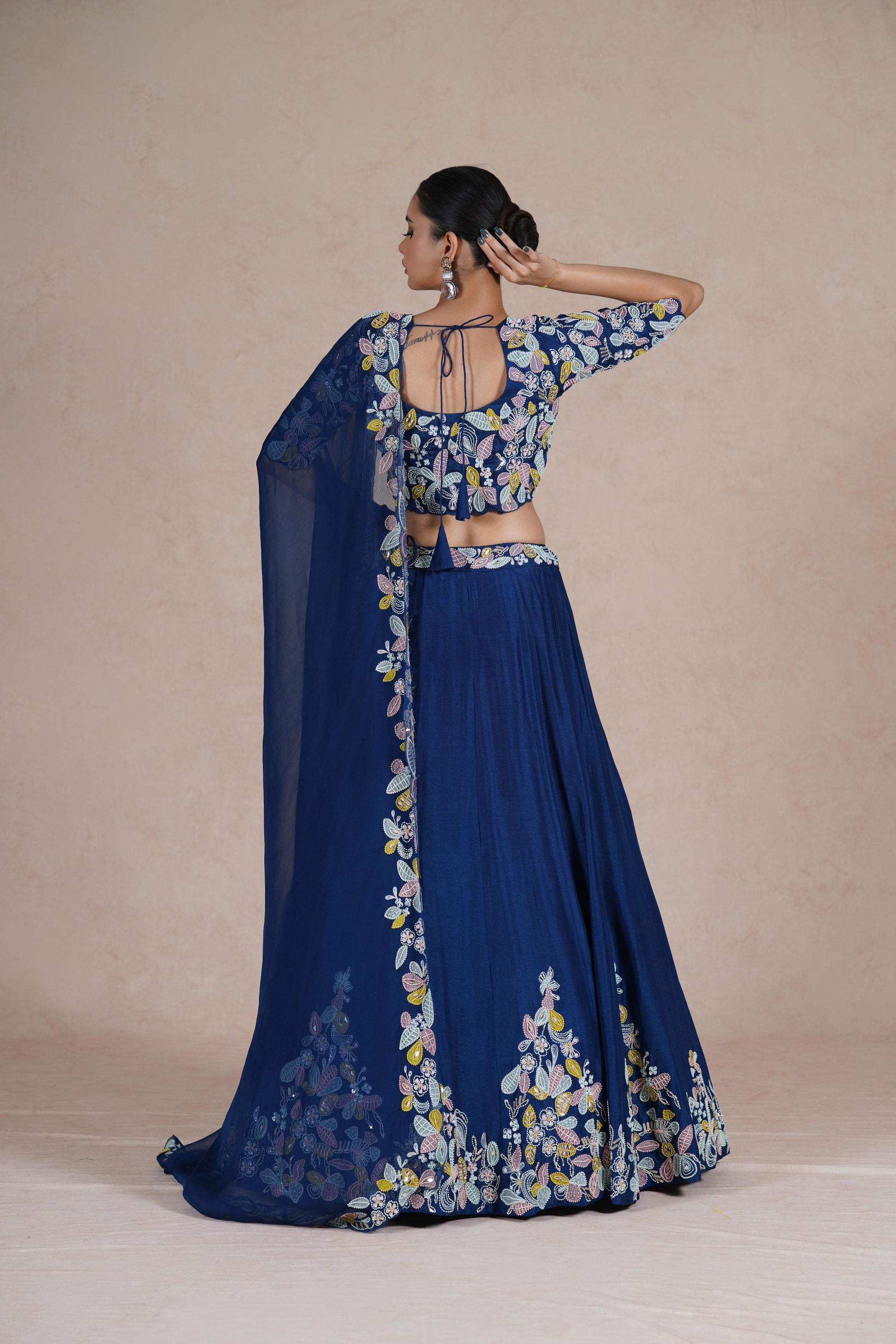 Artistic pose emphasizing the intricate design and luxurious appeal of the Royal Blue Lehenga Choli.