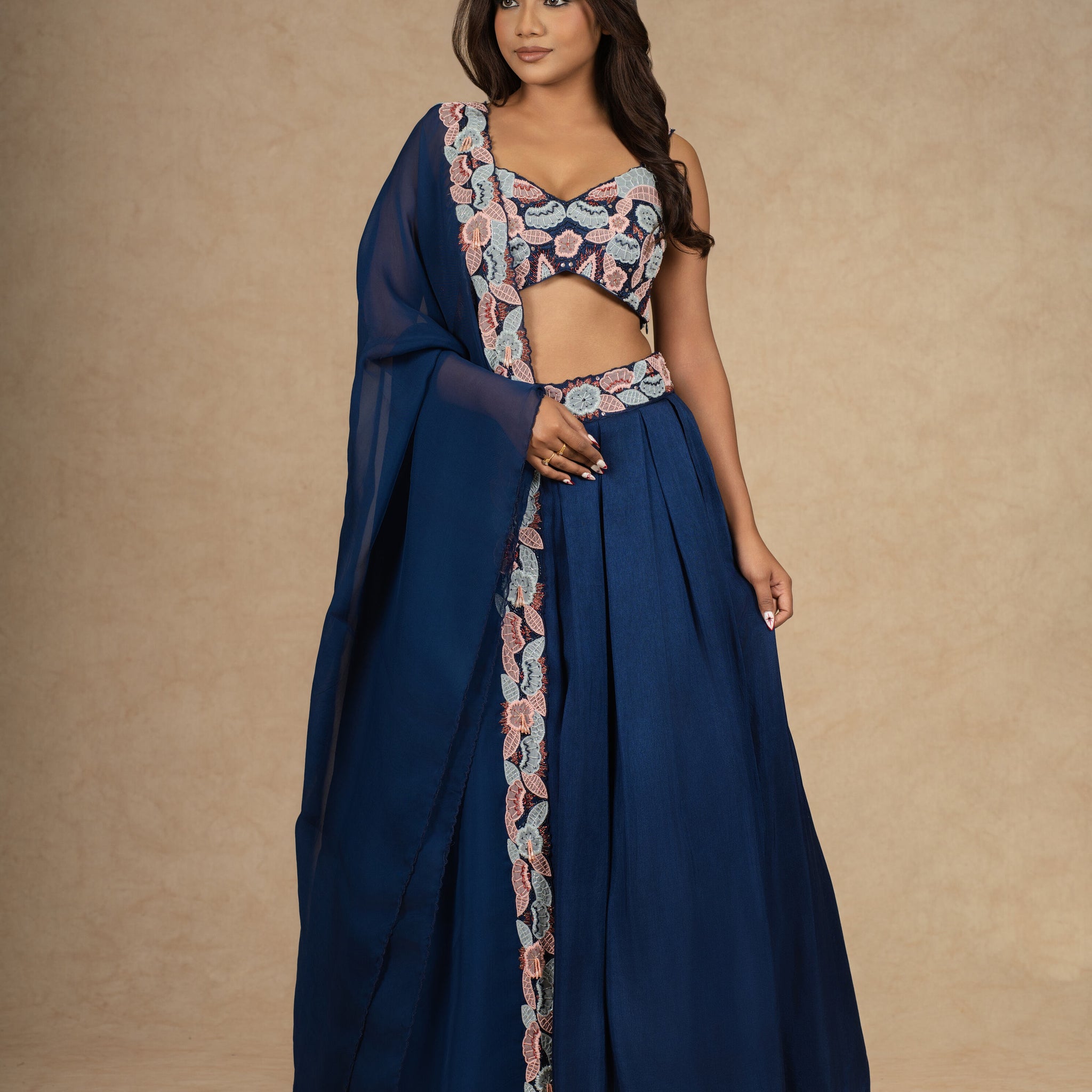 Royal blue lehenga choli with intricate embroidery, paired with a flowy organza dupatta.