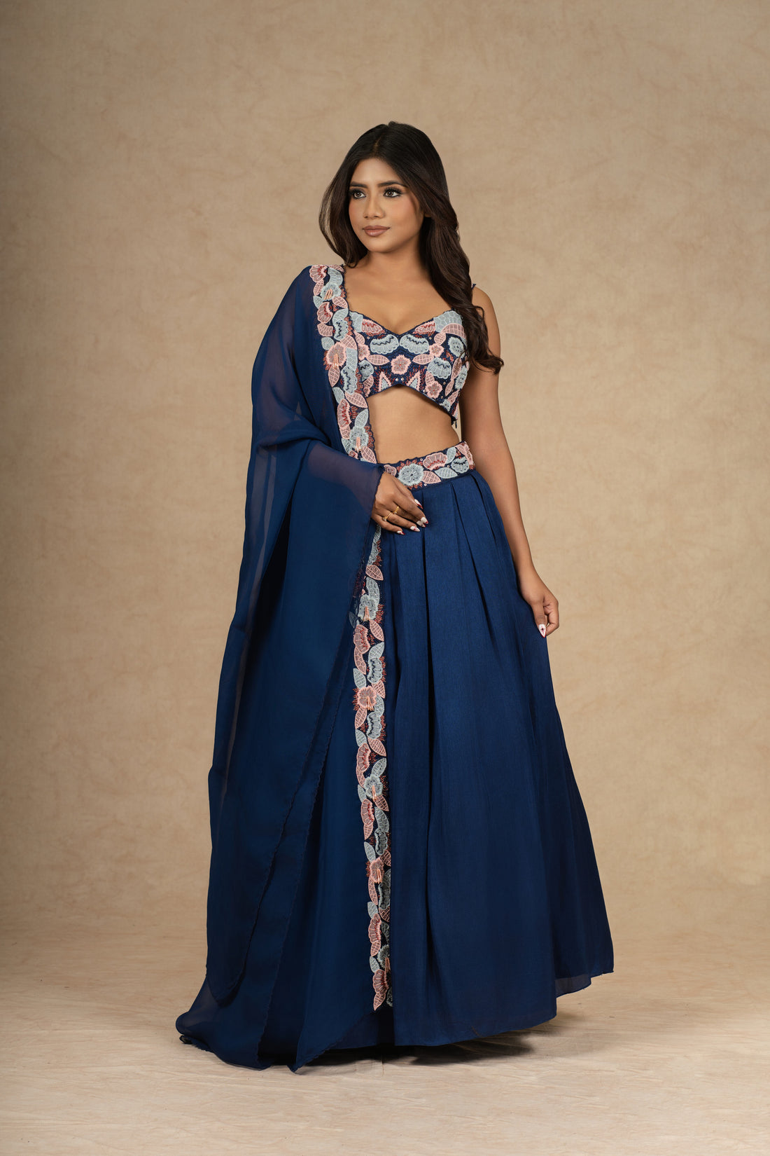 Royal blue lehenga choli with intricate embroidery, paired with a flowy organza dupatta.