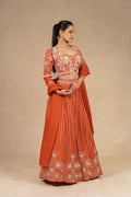 Stunning rust-colored lehenga choli with a beautifully embroidered choli and a pleated lehenga.