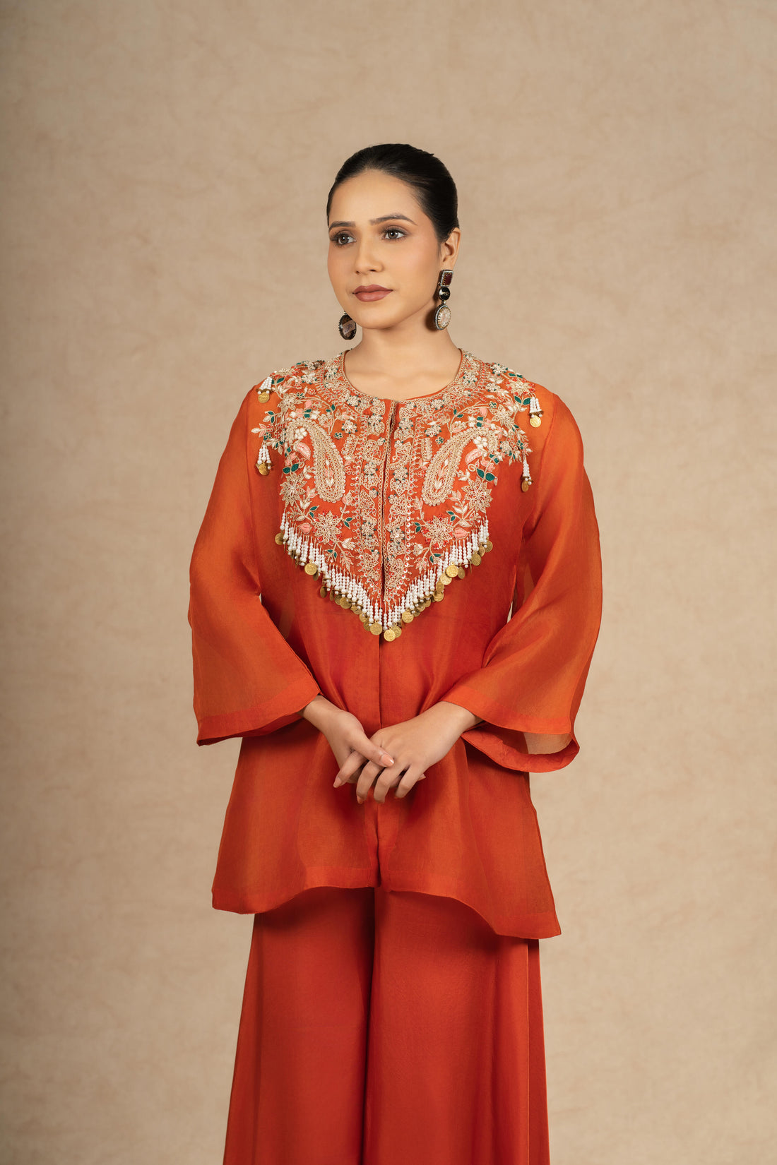 Model showcasing a Rust Organza Indo-Western outfit with intricate embroidery on the bodice and flared pants