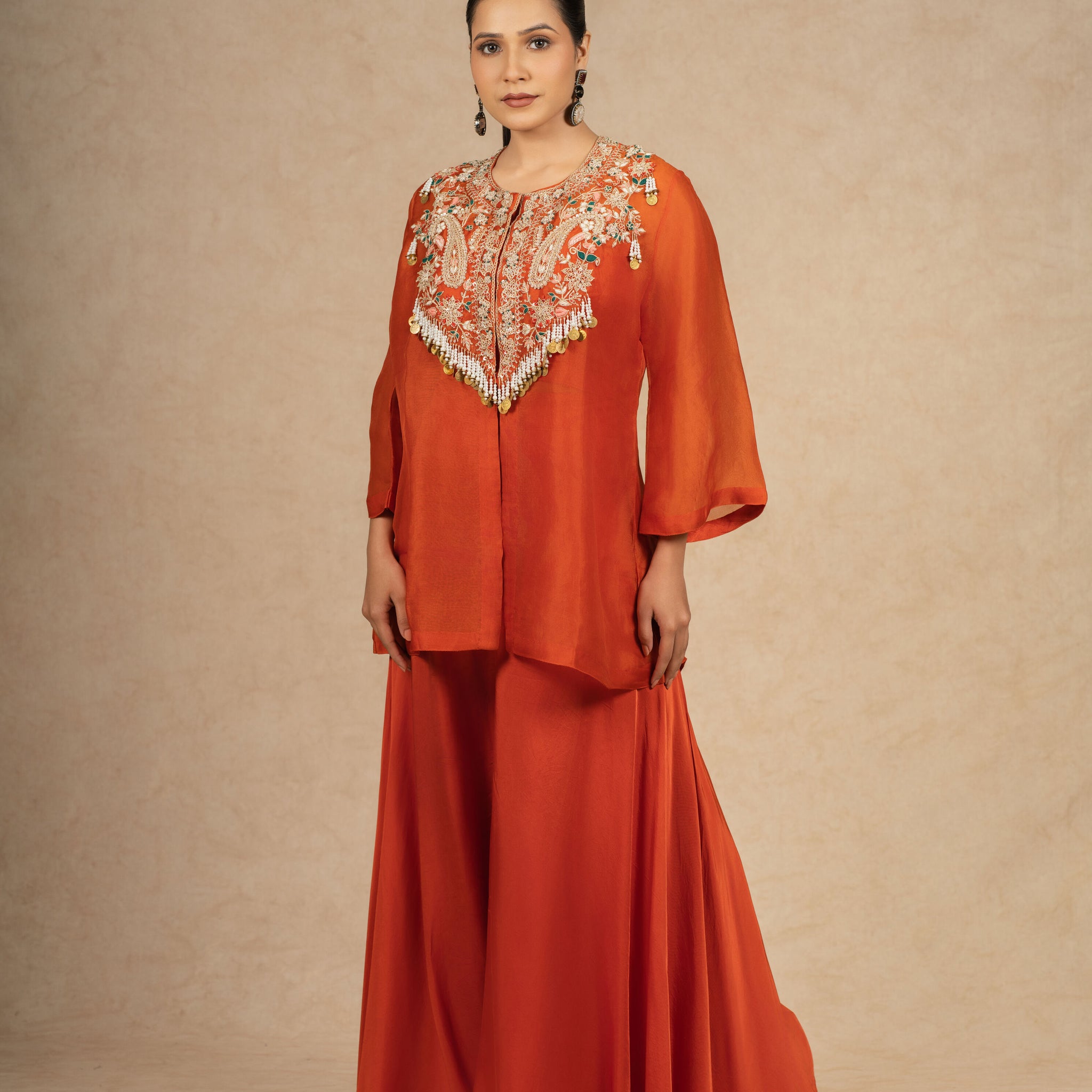 Model showcasing a Rust Organza Indo-Western outfit with intricate embroidery on the bodice and flared pants