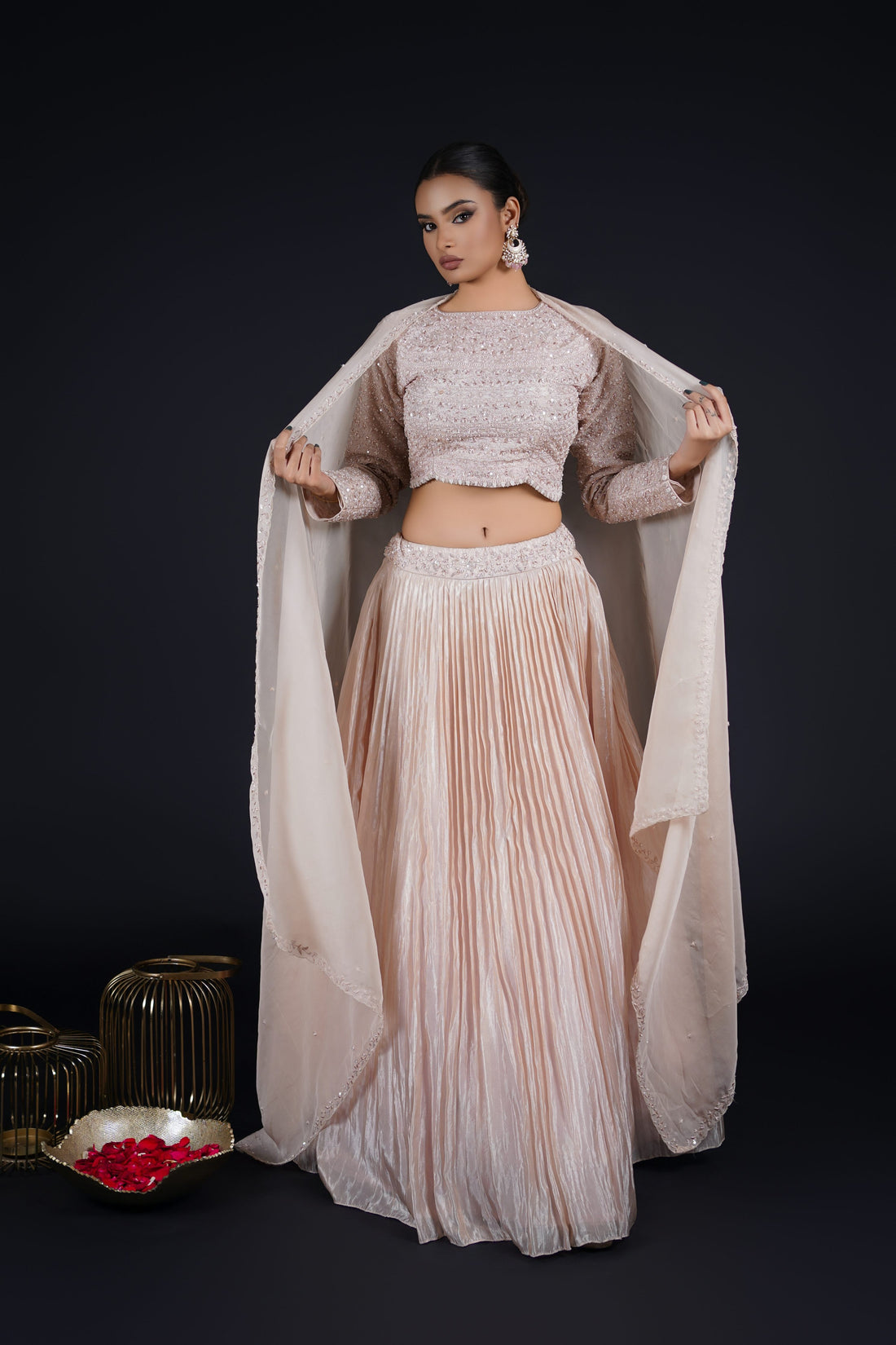 Model posing gracefully in a Tissue Rose Pink Lehenga with a full-sleeved choli and organza dupatta, adorned with pearls, sequins, and zardozi.