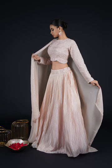 Model posing gracefully in a Tissue Rose Pink Lehenga with a full-sleeved choli and organza dupatta, adorned with pearls, sequins, and zardozi.