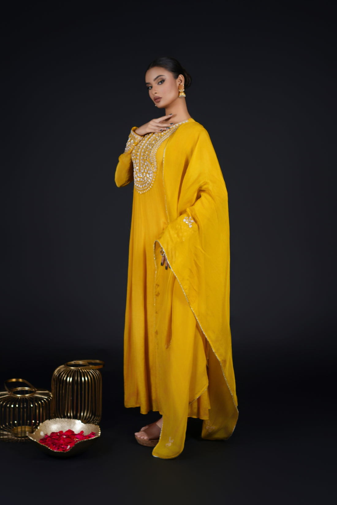 Model gracefully twirling in a Yellow Kalidar Anarkali Suit, showcasing its fluid silhouette and intricate zardozi and gotta patti embroidery.
