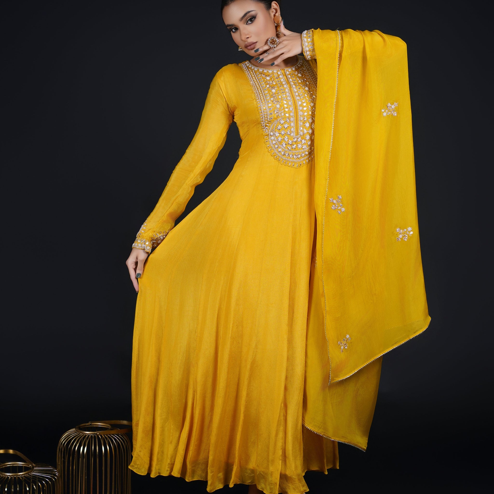 Model gracefully twirling in a Yellow Kalidar Anarkali Suit, showcasing its fluid silhouette and intricate zardozi and gotta patti embroidery.
